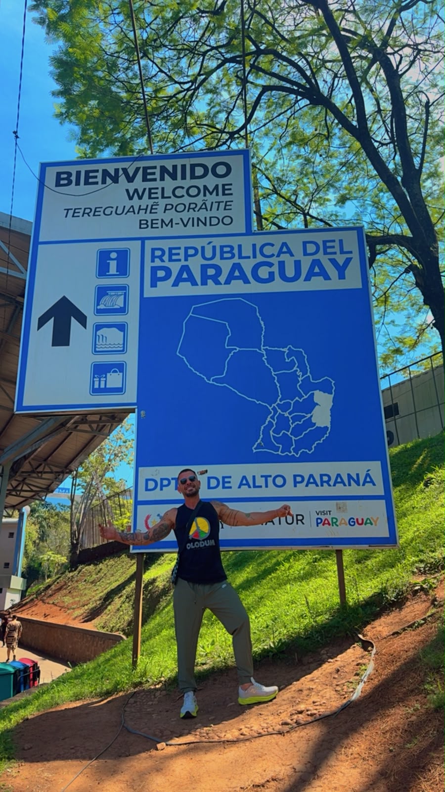 Pessoa em frente à placa de boas-vindas da República do Paraguai, no departamento de Alto Paraná.